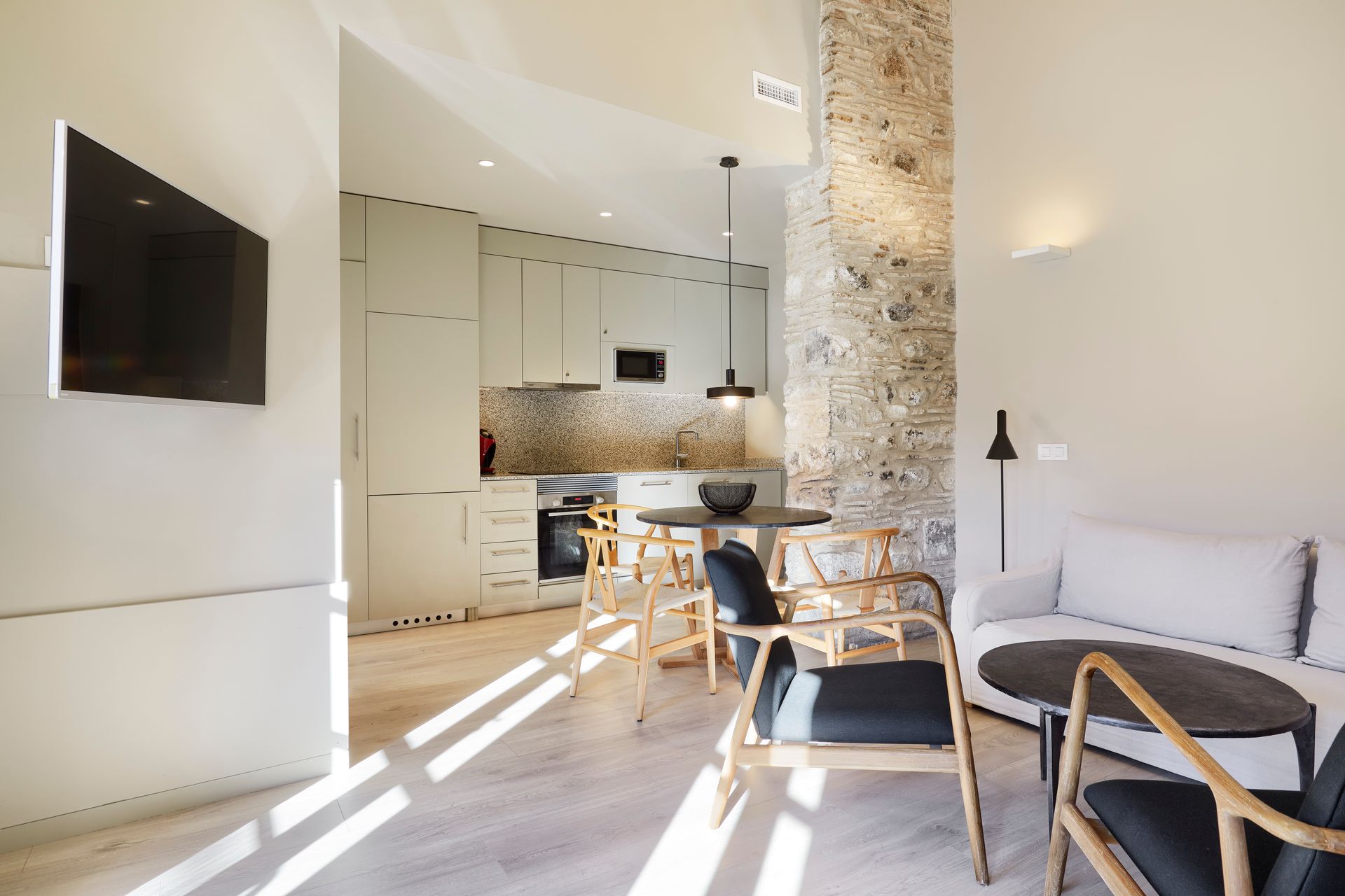 A living room with a couch and chairs and a flat screen tv