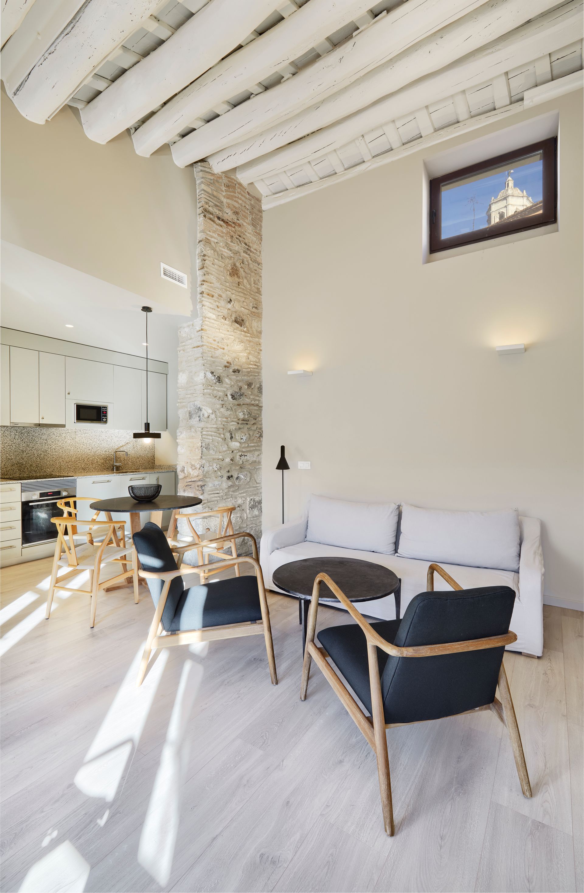 A living room with a couch , chairs , a table and a window.