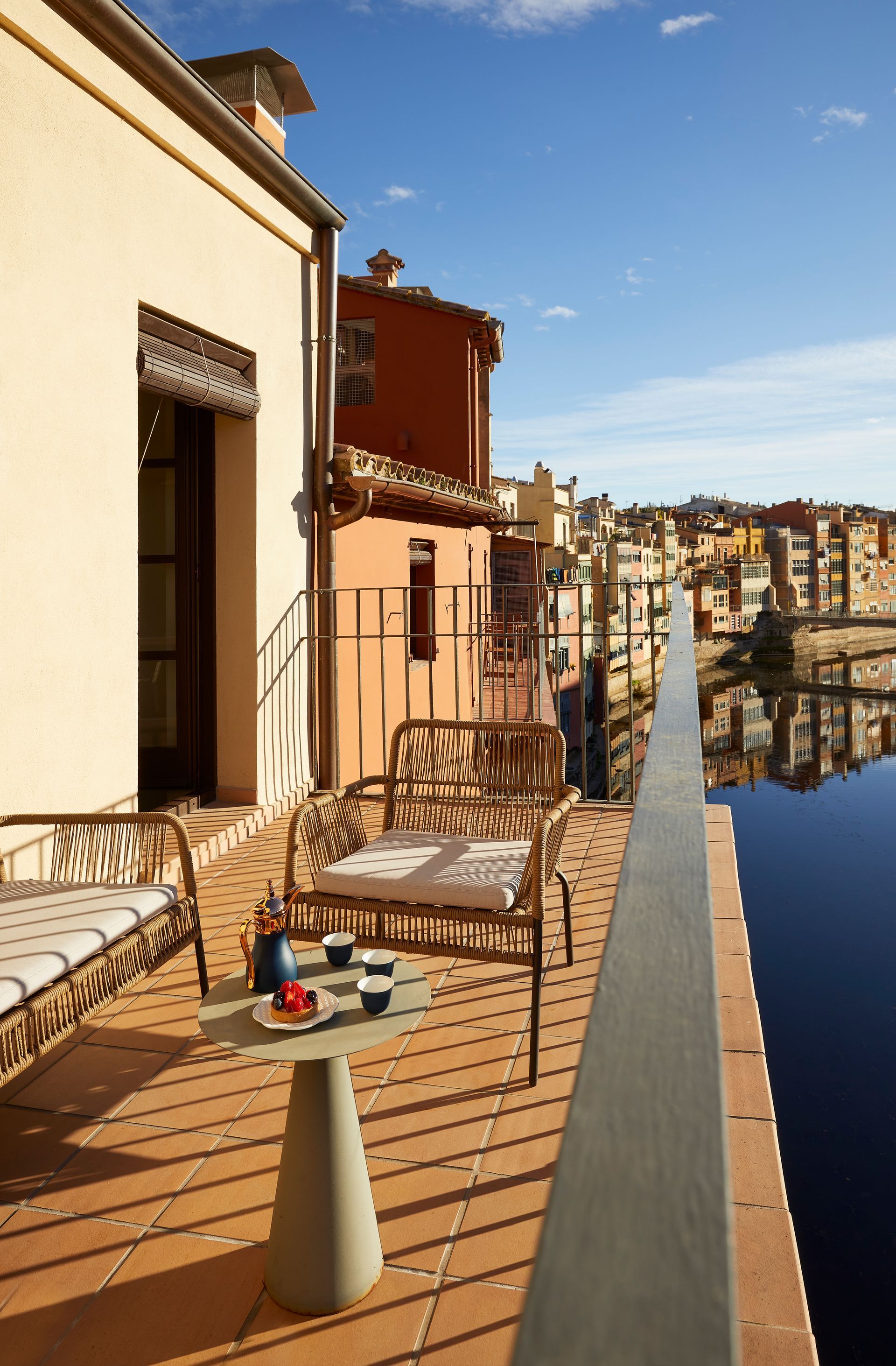 A balcony with a table and chairs overlooking a body of water
