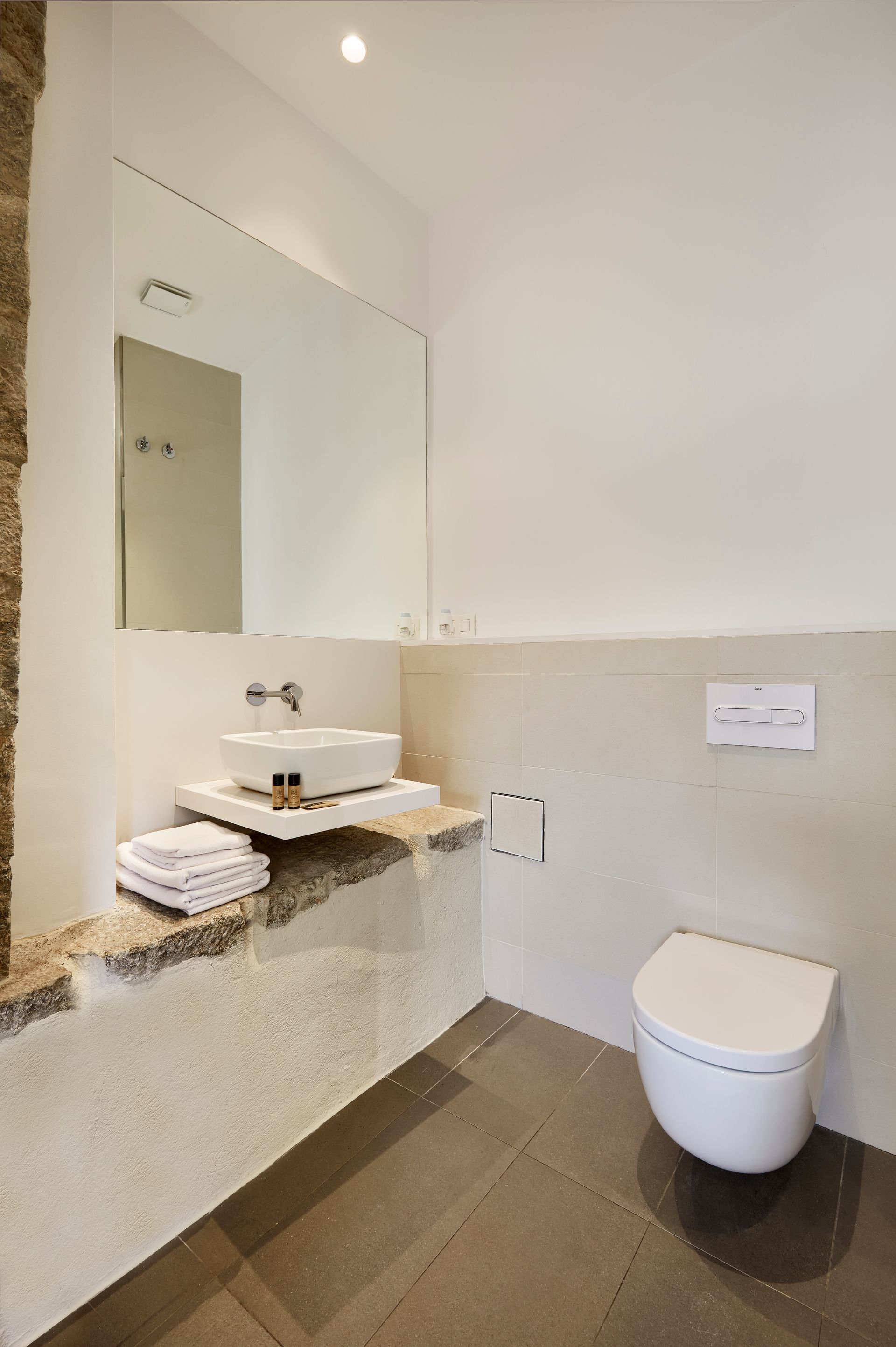 A bathroom with a sink , toilet and mirror.