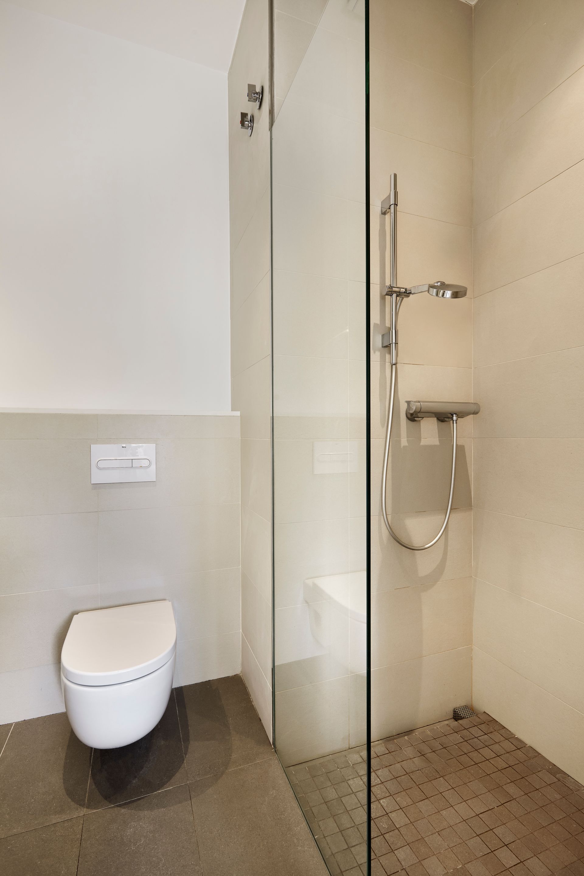 A bathroom with a toilet and a walk in shower