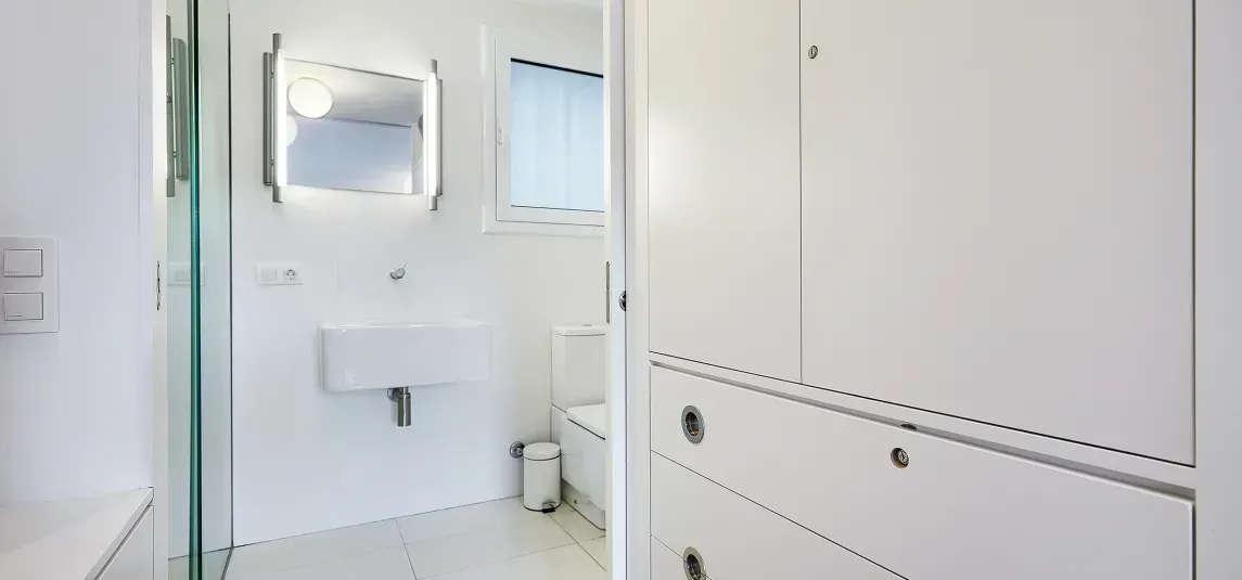A bathroom with a sink , toilet , mirror and walk in shower.