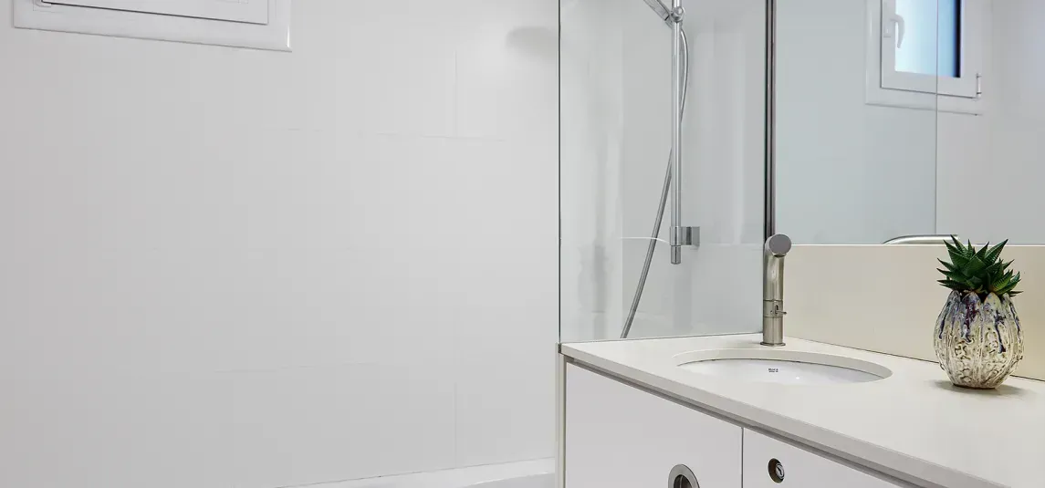 A bathroom with a sink , mirror and shower.