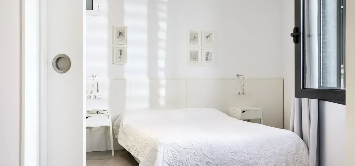 A bedroom with a single bed and a window.