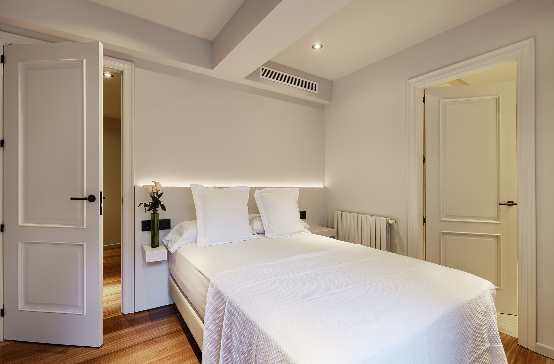 A bedroom with a bed and a door leading to a bathroom.