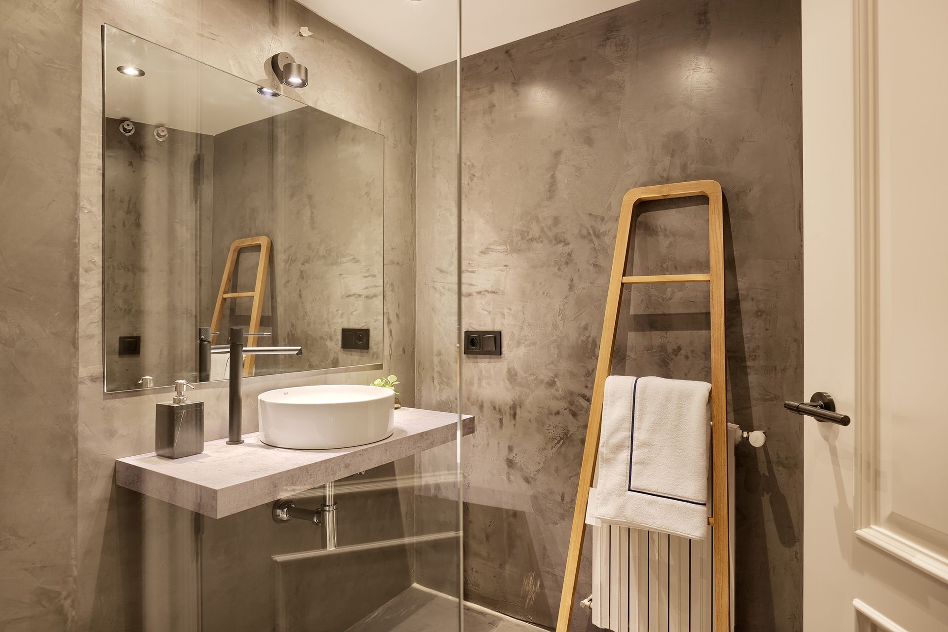 A bathroom with a sink , mirror , and towel rack.