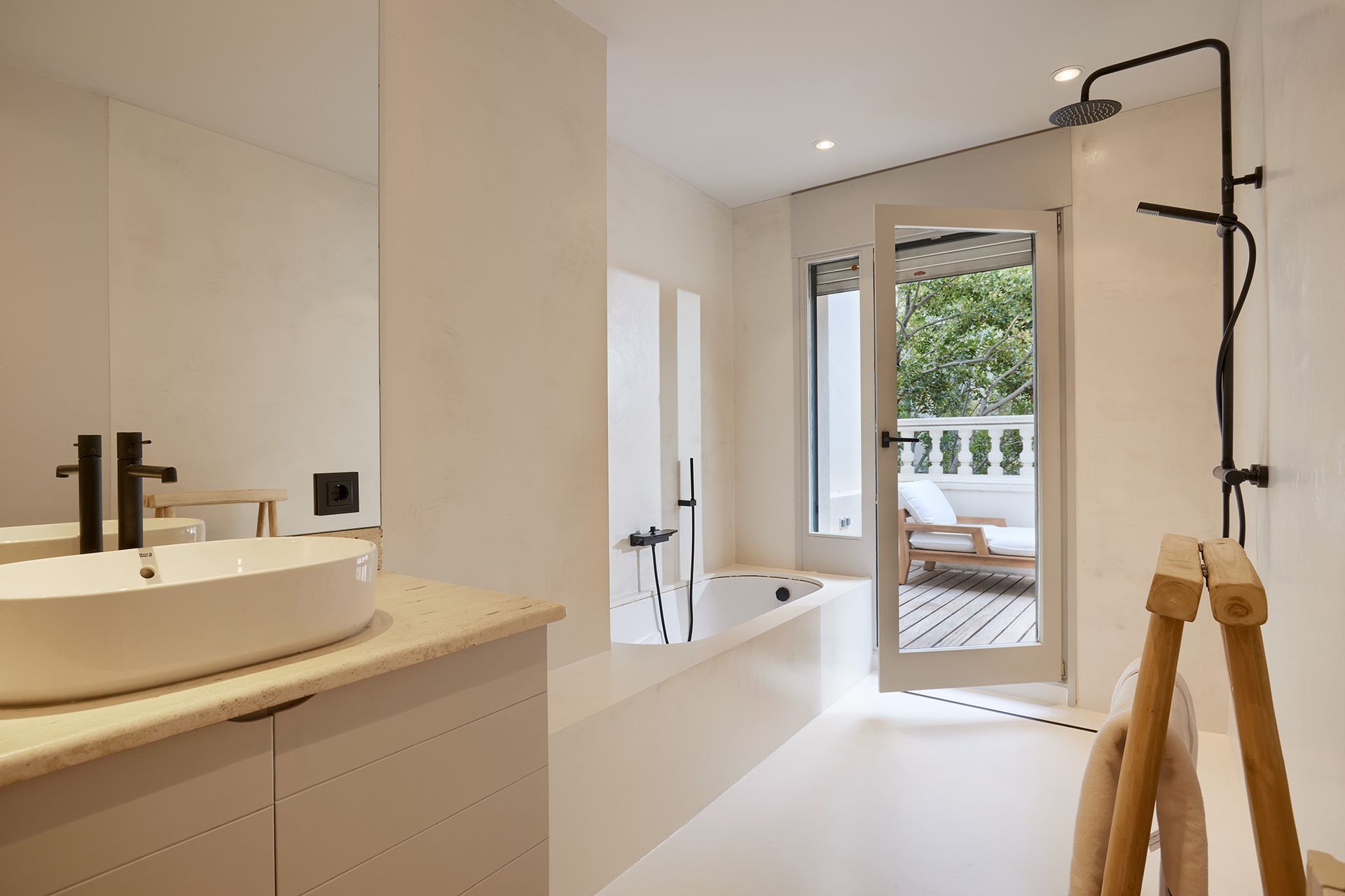 A bathroom with a tub , sink , mirror and shower.