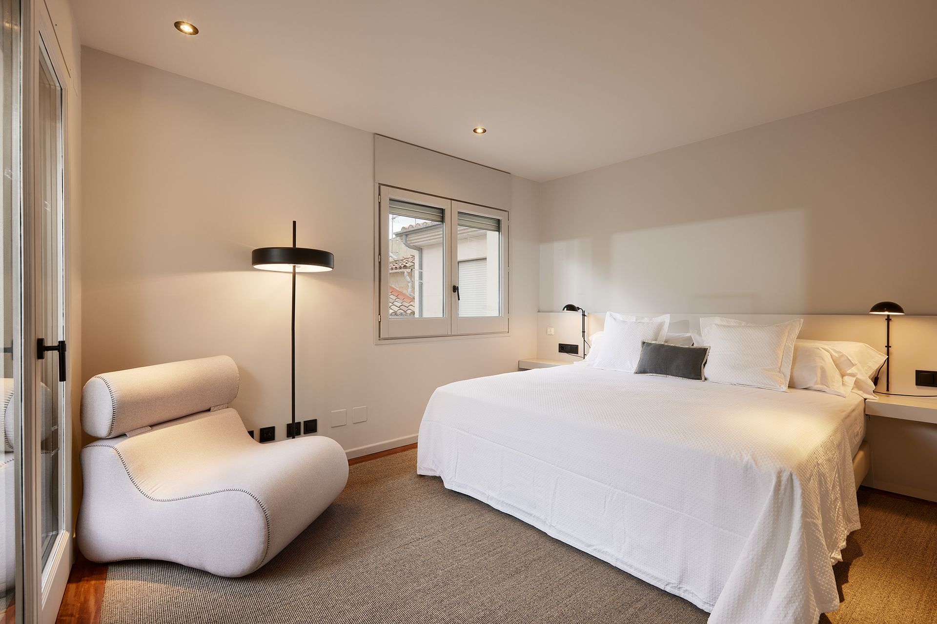 A bedroom with a large bed and a chair