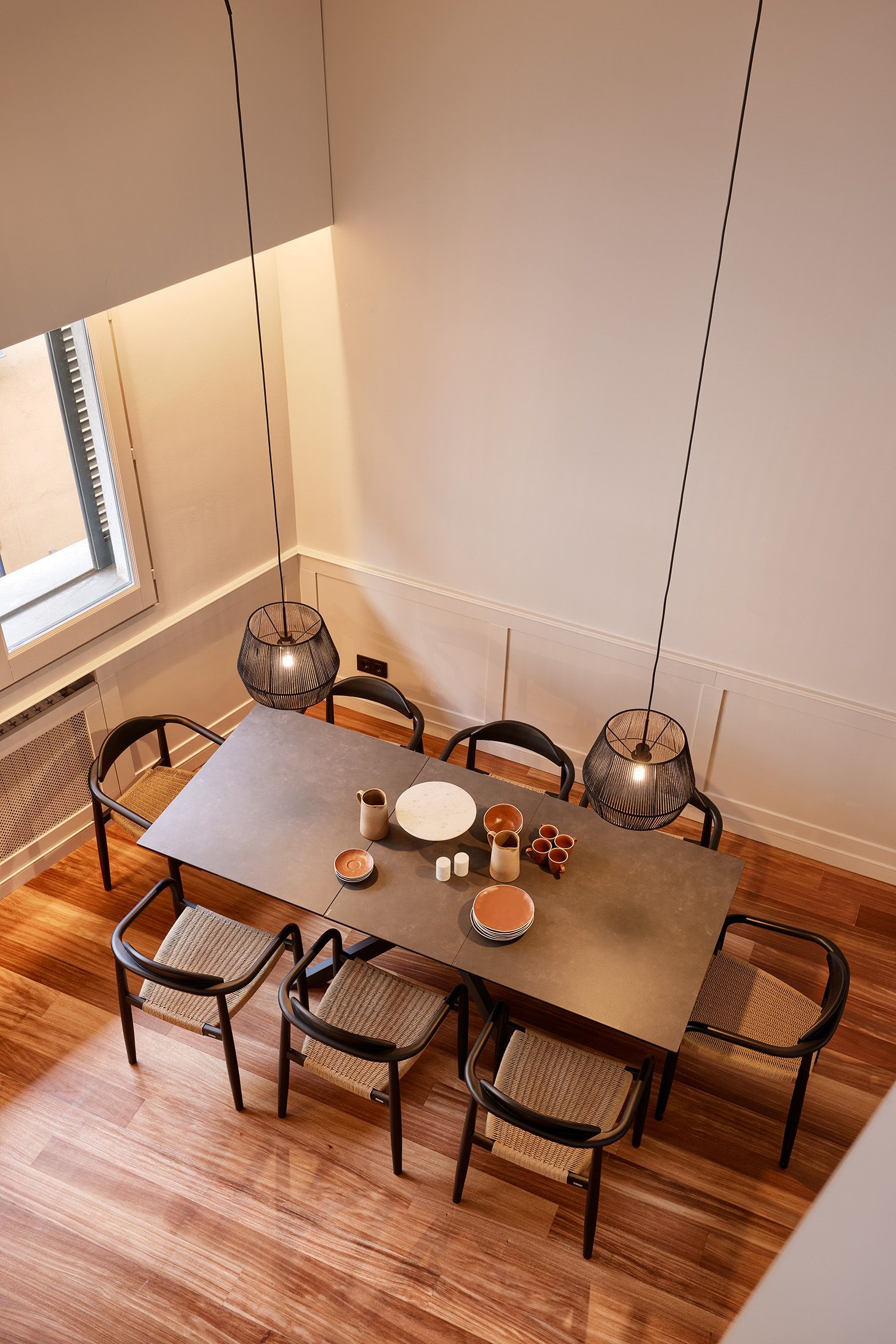 An aerial view of a dining room with a table and chairs.