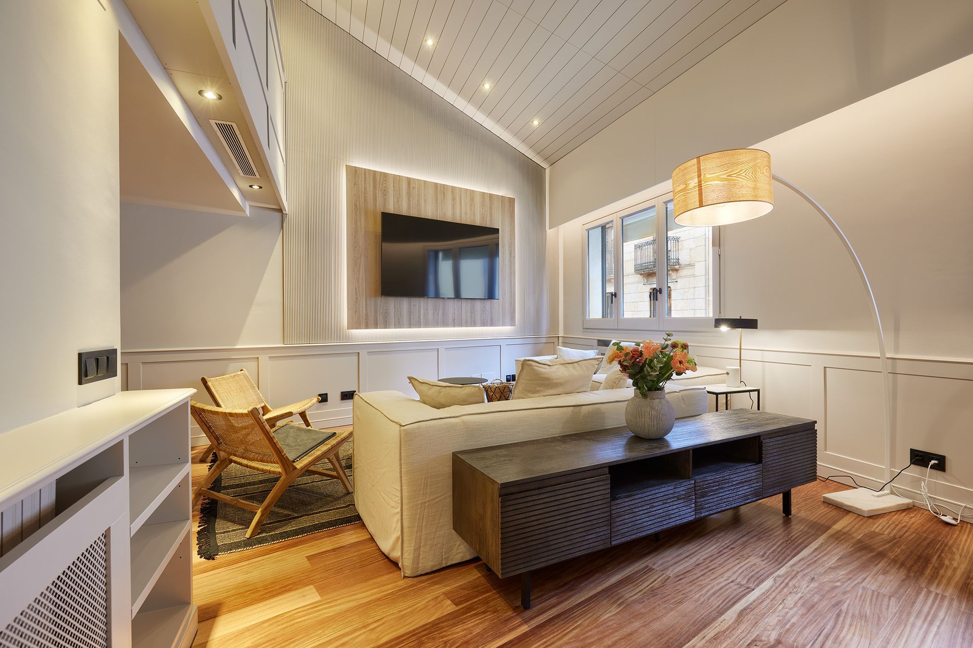 A living room with a couch , table , chairs and a flat screen tv.
