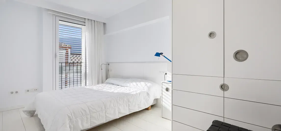 A bedroom with a bed , closet , and window.