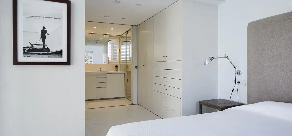 A bedroom with a bed and a picture on the wall.