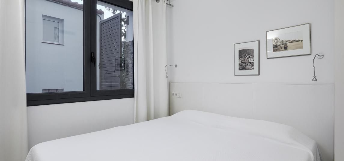 A bedroom with a bed , a window and a lamp.