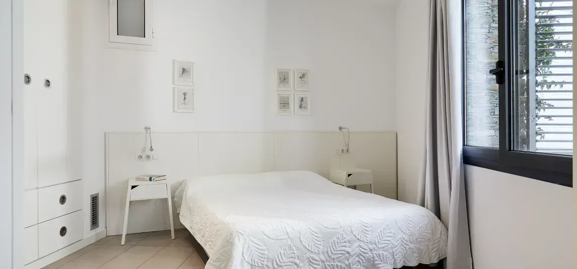 A bedroom with a single bed and a window.