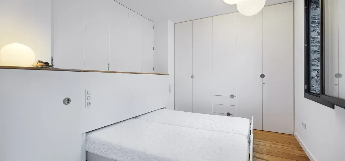 A bedroom with a bed and a mirror in it.