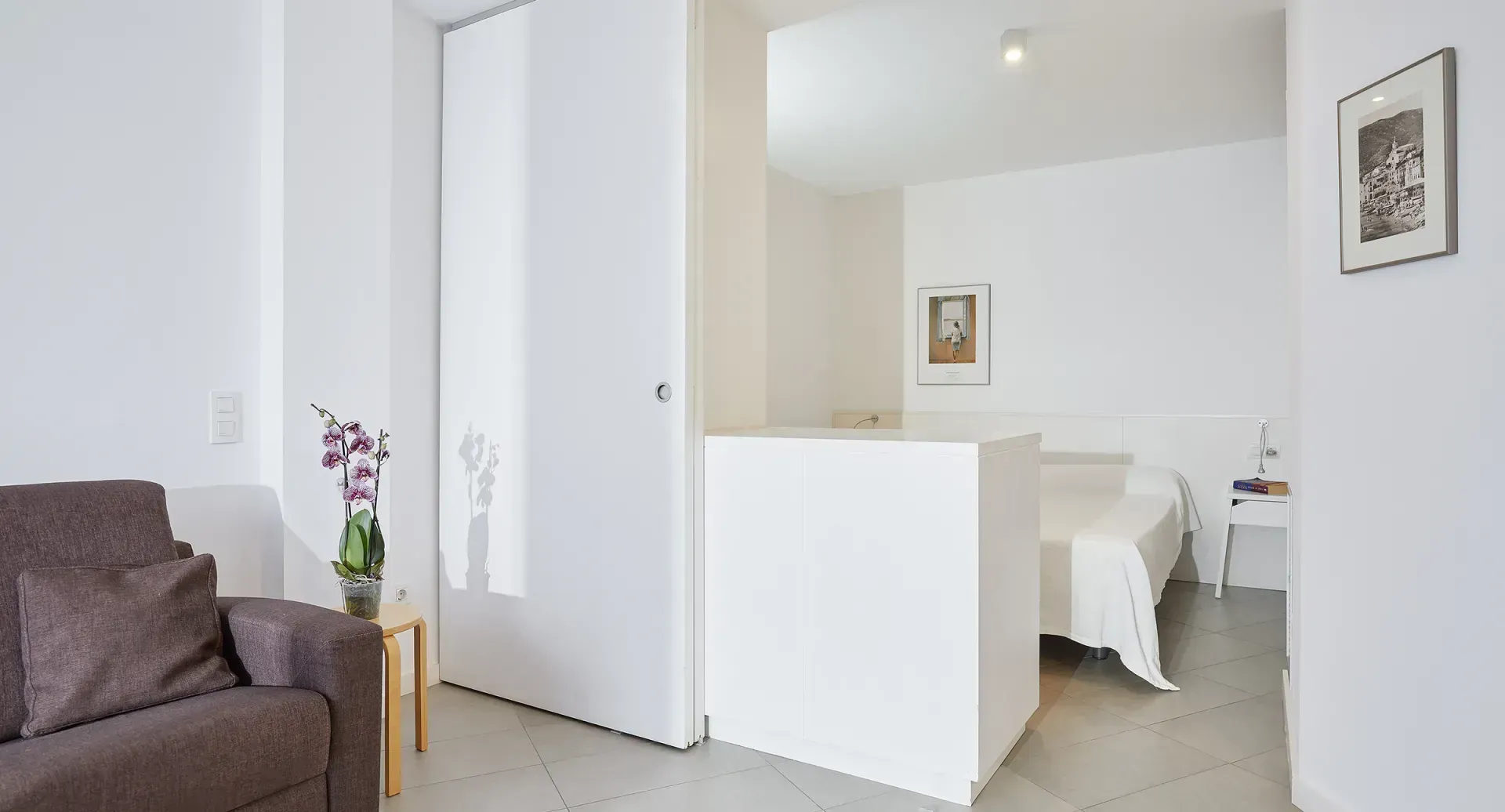 A living room with a couch and a bed in the background