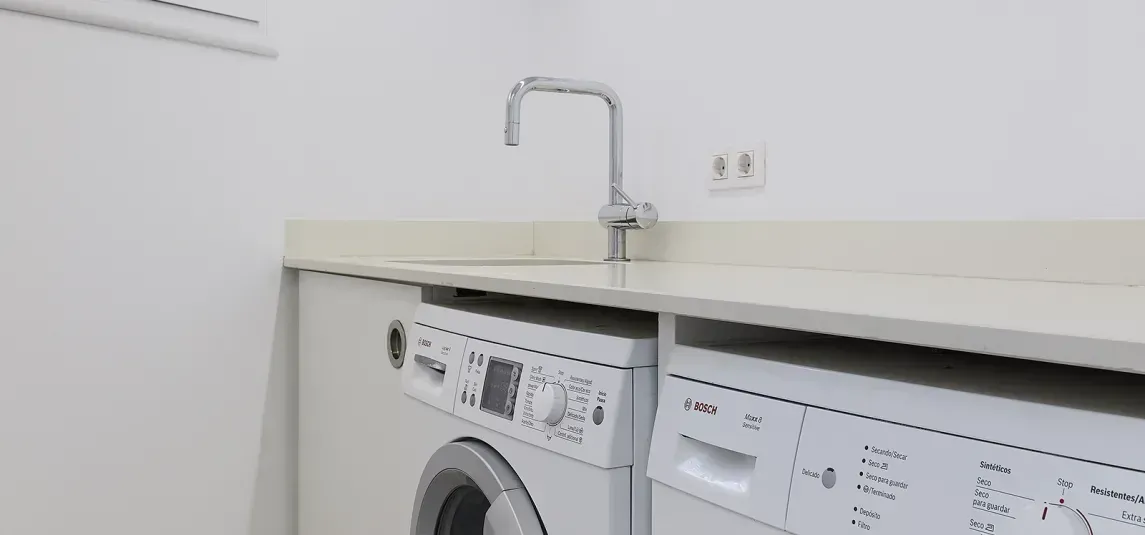 A laundry room with a washer and dryer and a sink.