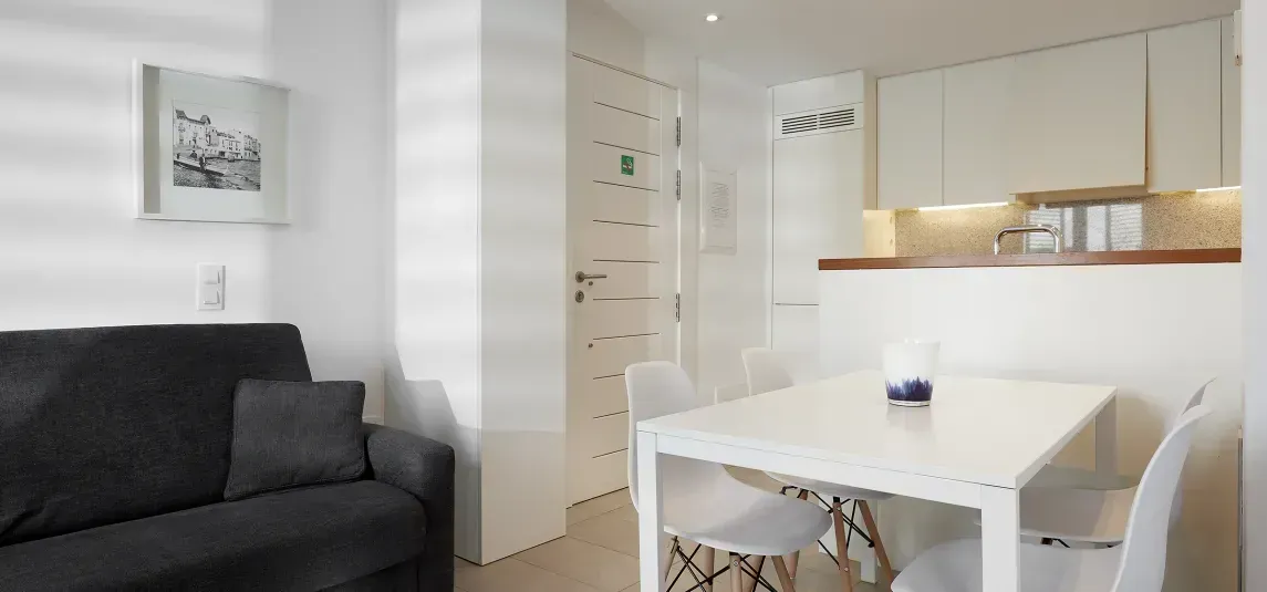 A living room with a couch , table and chairs.