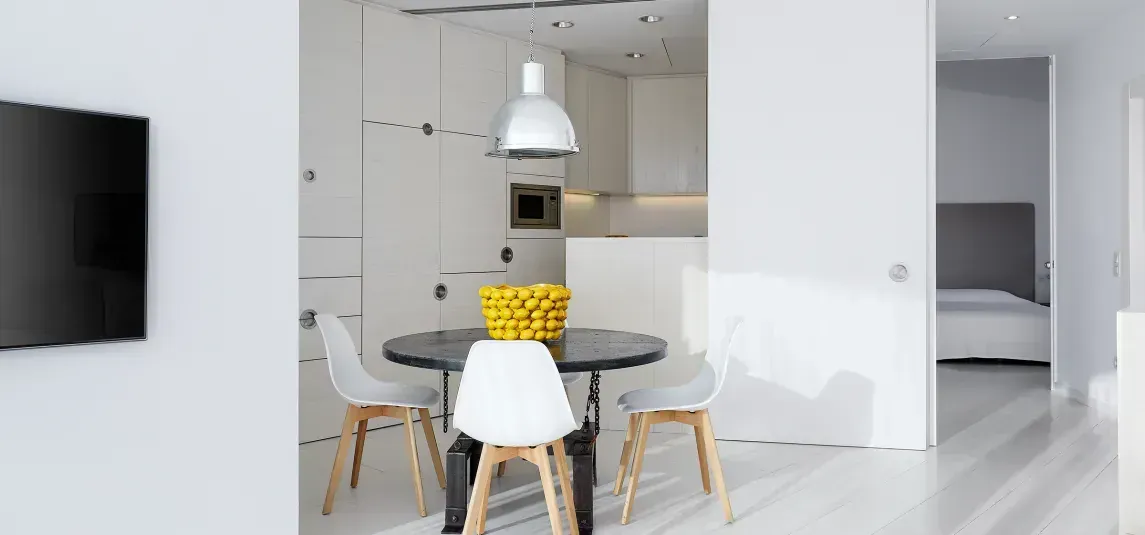 A living room with a table and chairs and a flat screen tv.