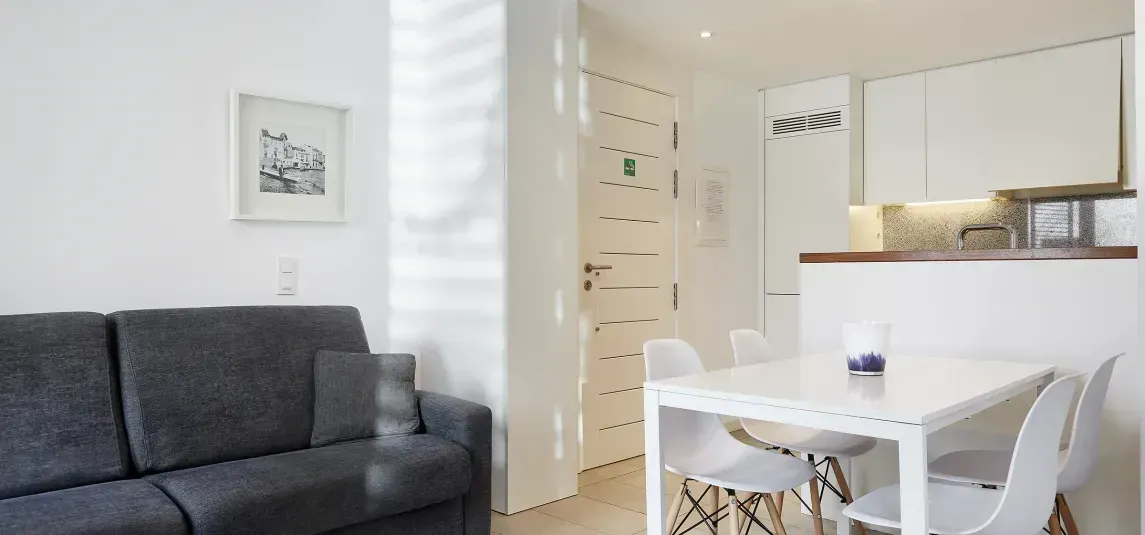 A living room with a couch , table and chairs