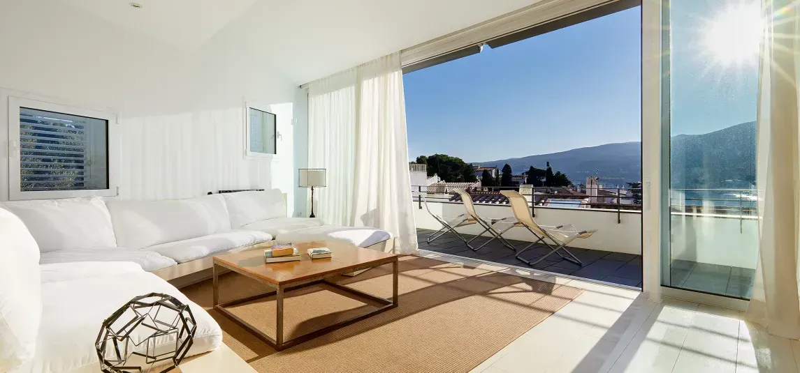 A living room with a couch , coffee table , and sliding glass doors.