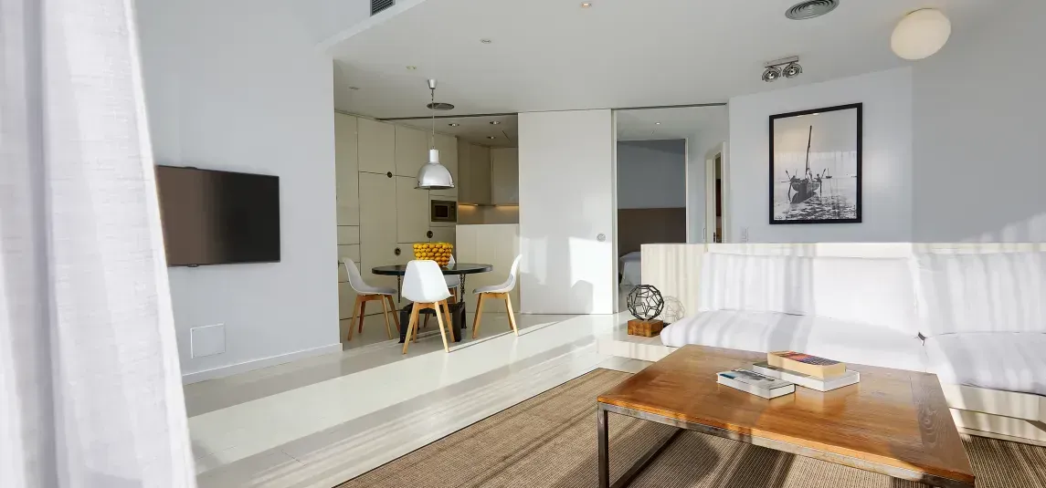 A living room with a couch , table , chairs and a television.