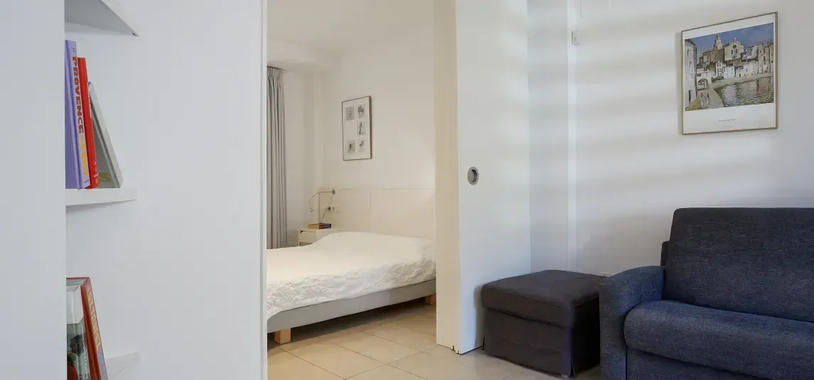 A living room with a couch and a bed.