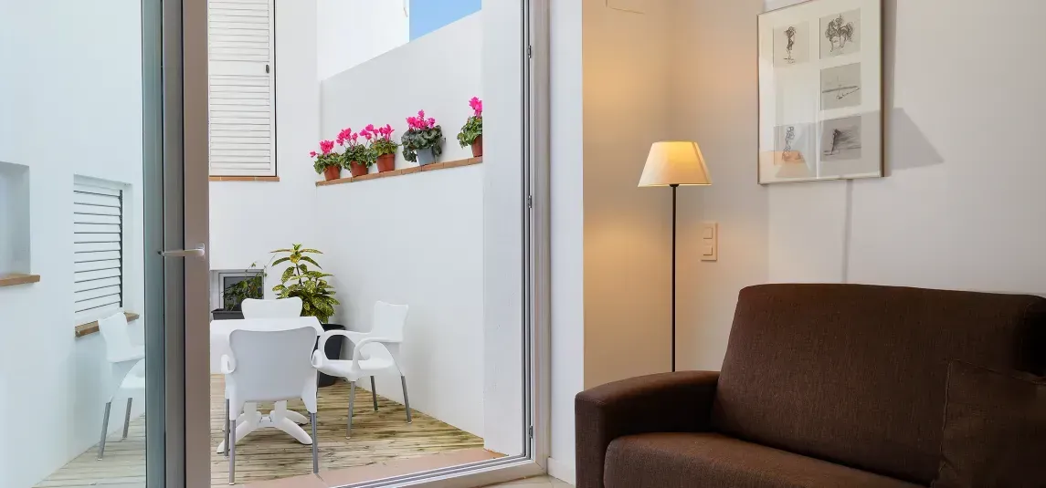 A living room with a couch and a table and chairs.