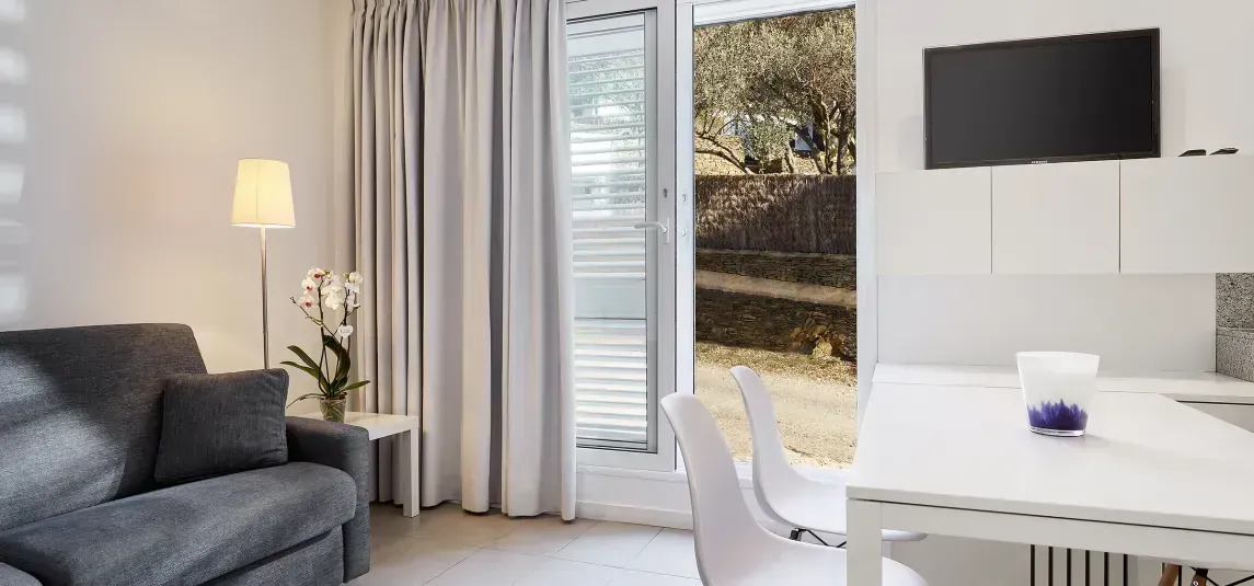 A living room with a couch , table , chairs and a television.