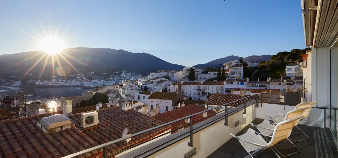 A balcony with a view of a city and mountains.