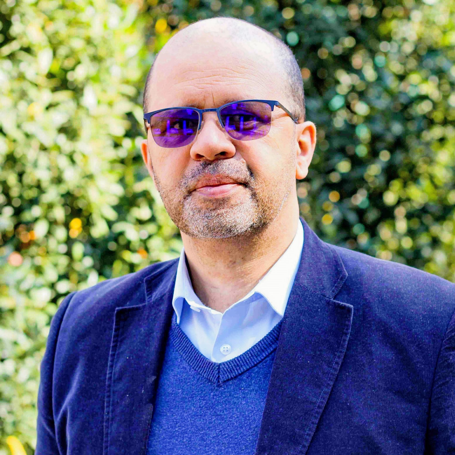 An older man wearing glasses is smiling for the camera