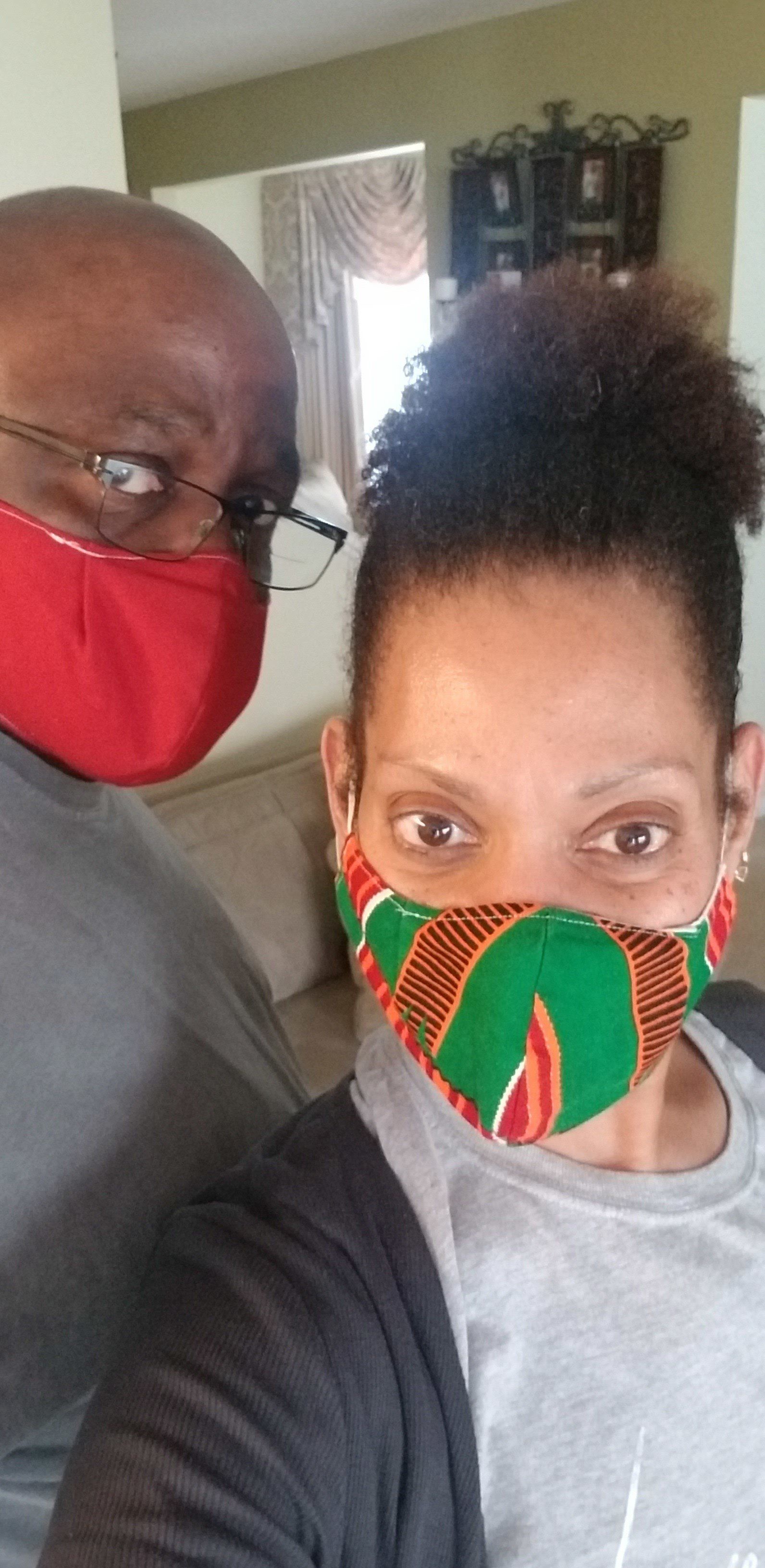 A man and a woman wearing face masks are taking a selfie.