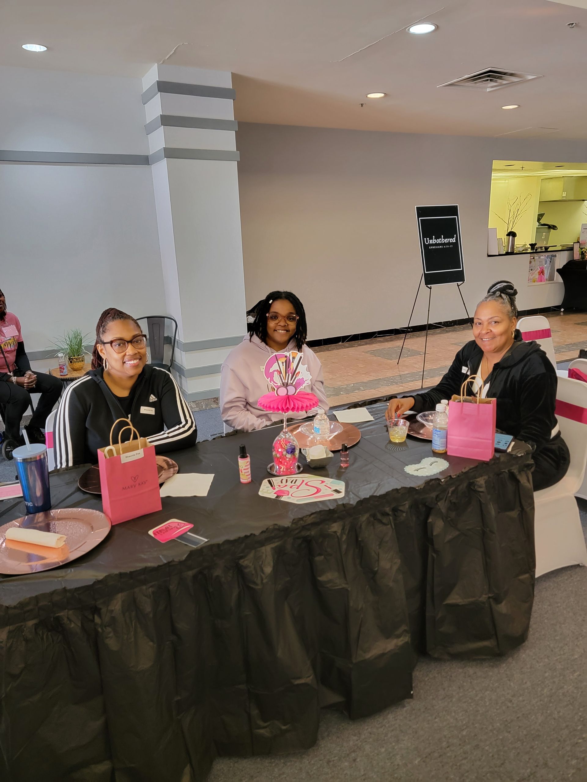 A group of women are sitting at a table in a room.