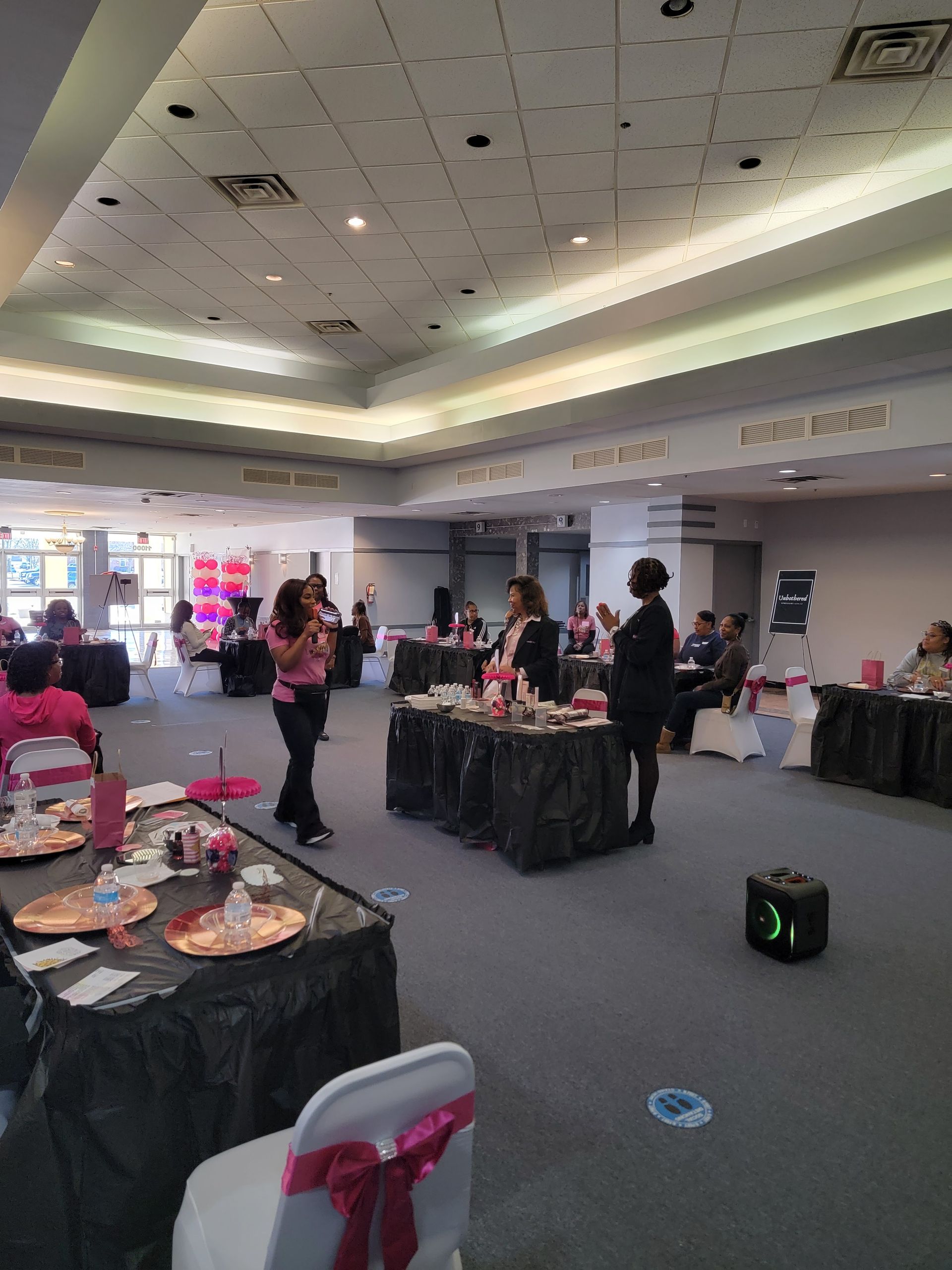 A large room with tables and chairs set up for a party.