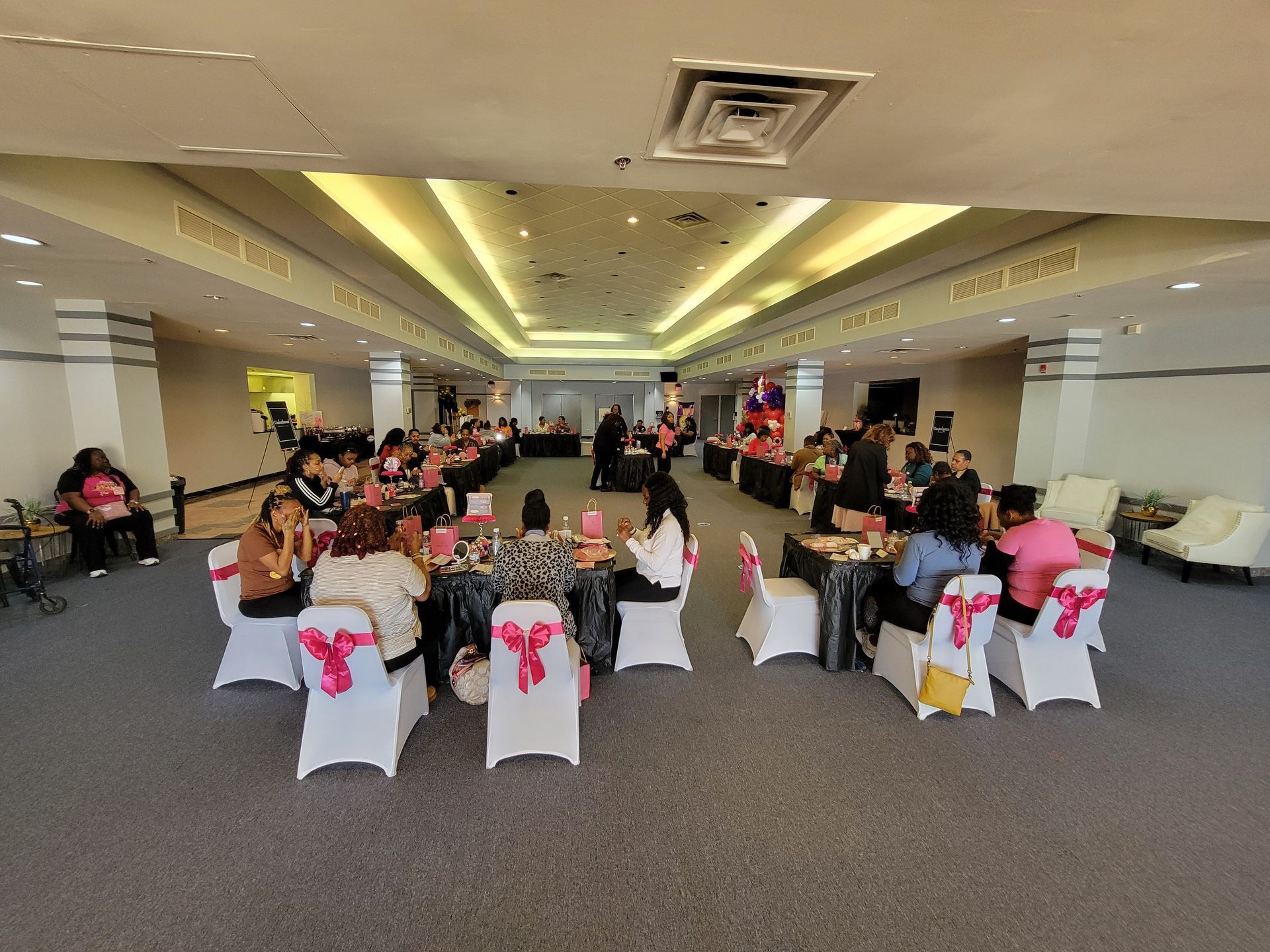 A group of people are sitting at tables in a large room.