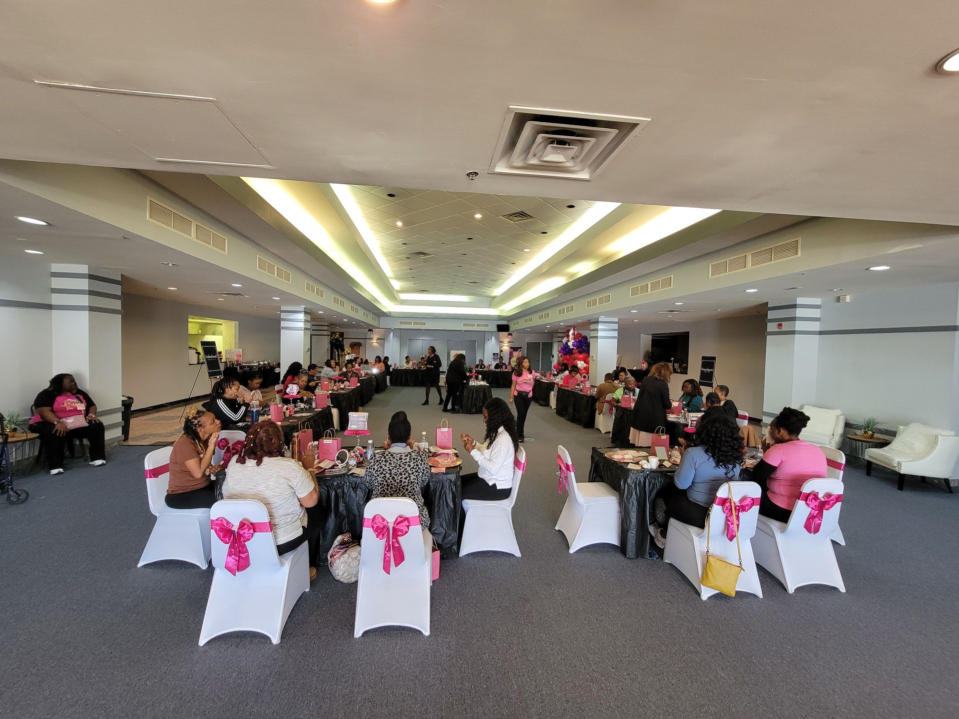 A group of people are sitting at tables in a large room.