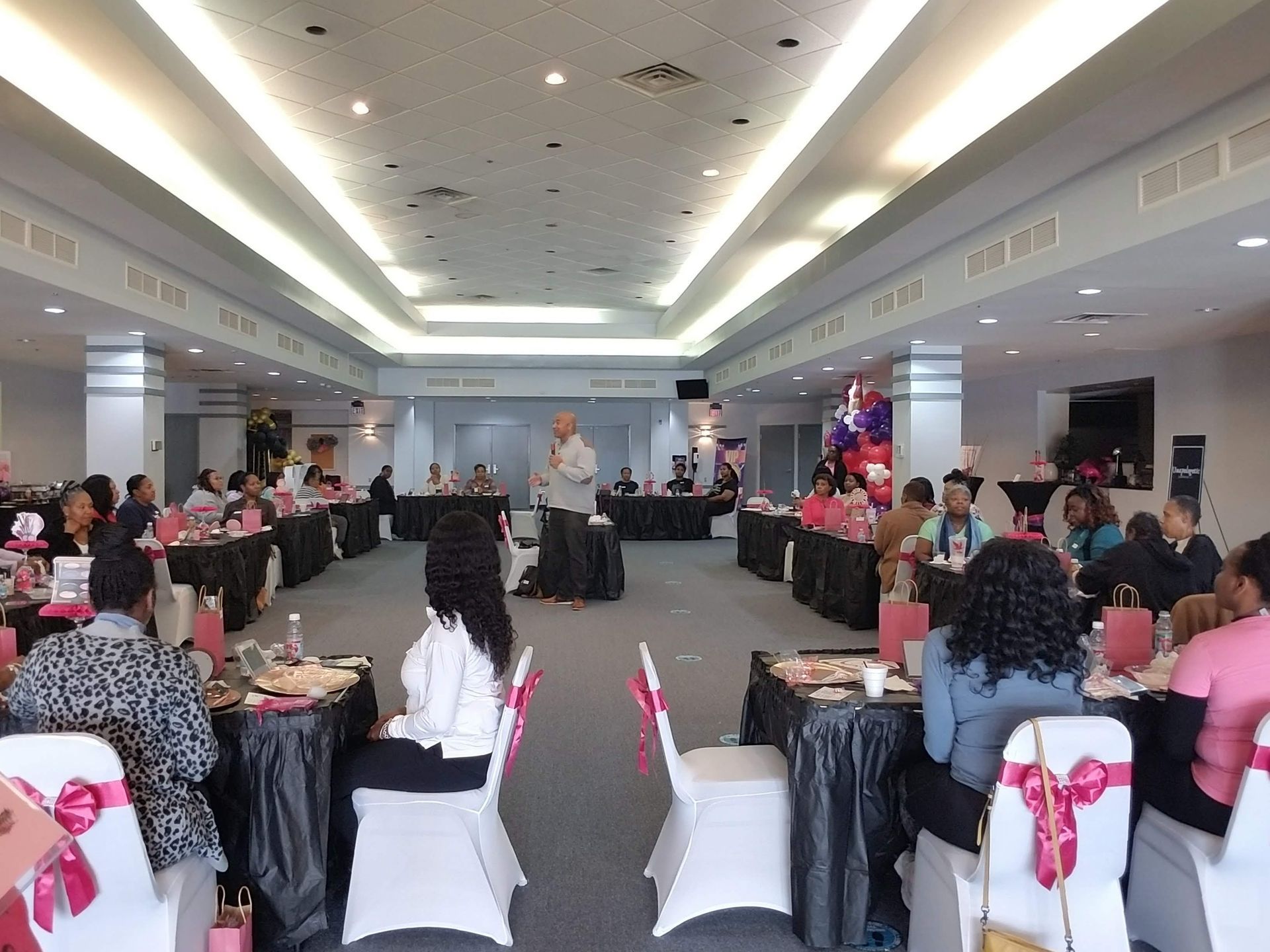 A group of people are sitting at tables in a large room