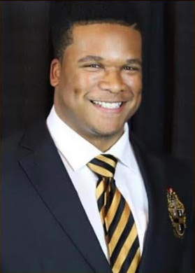 A man in a suit and tie is smiling for the camera.