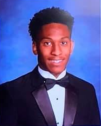 A young man in a tuxedo and bow tie is posing for a picture.