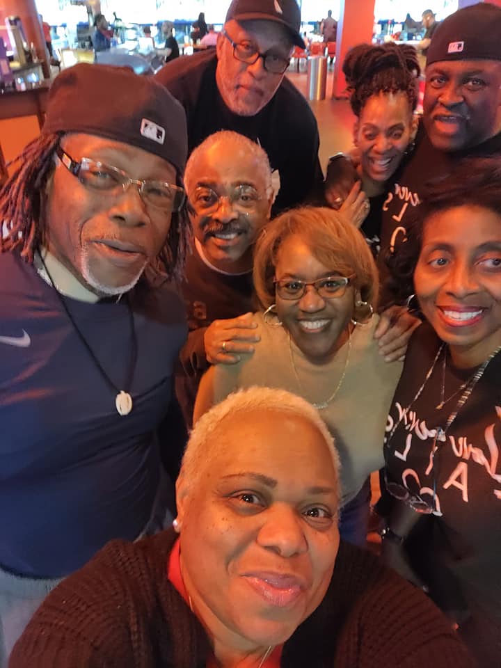 A group of people posing for a picture with one wearing a nike shirt