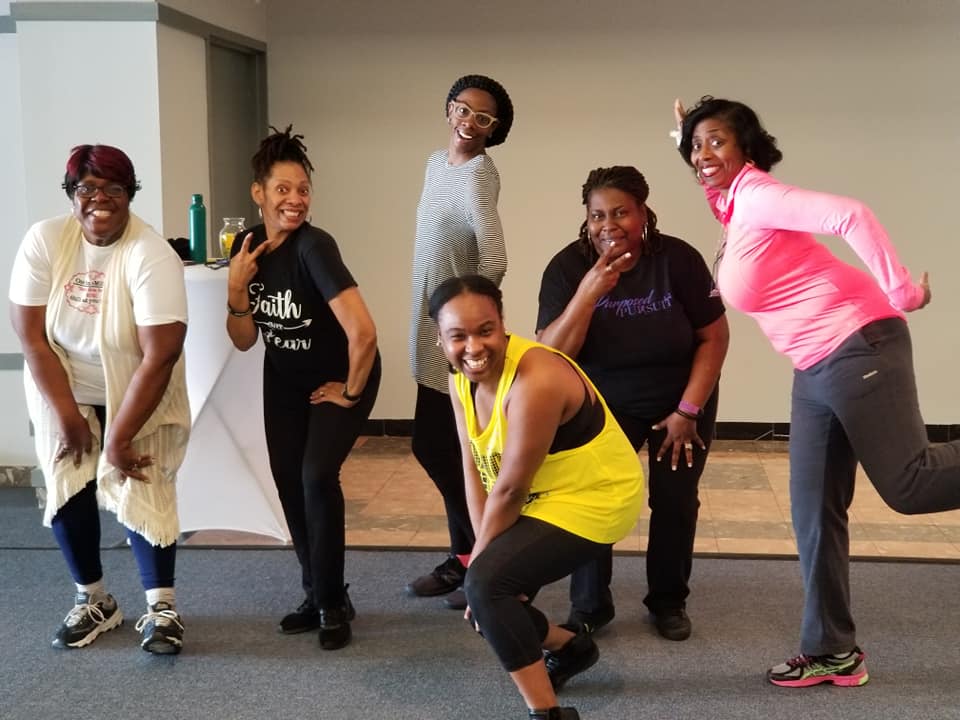 A group of women are posing for a picture in a room.
