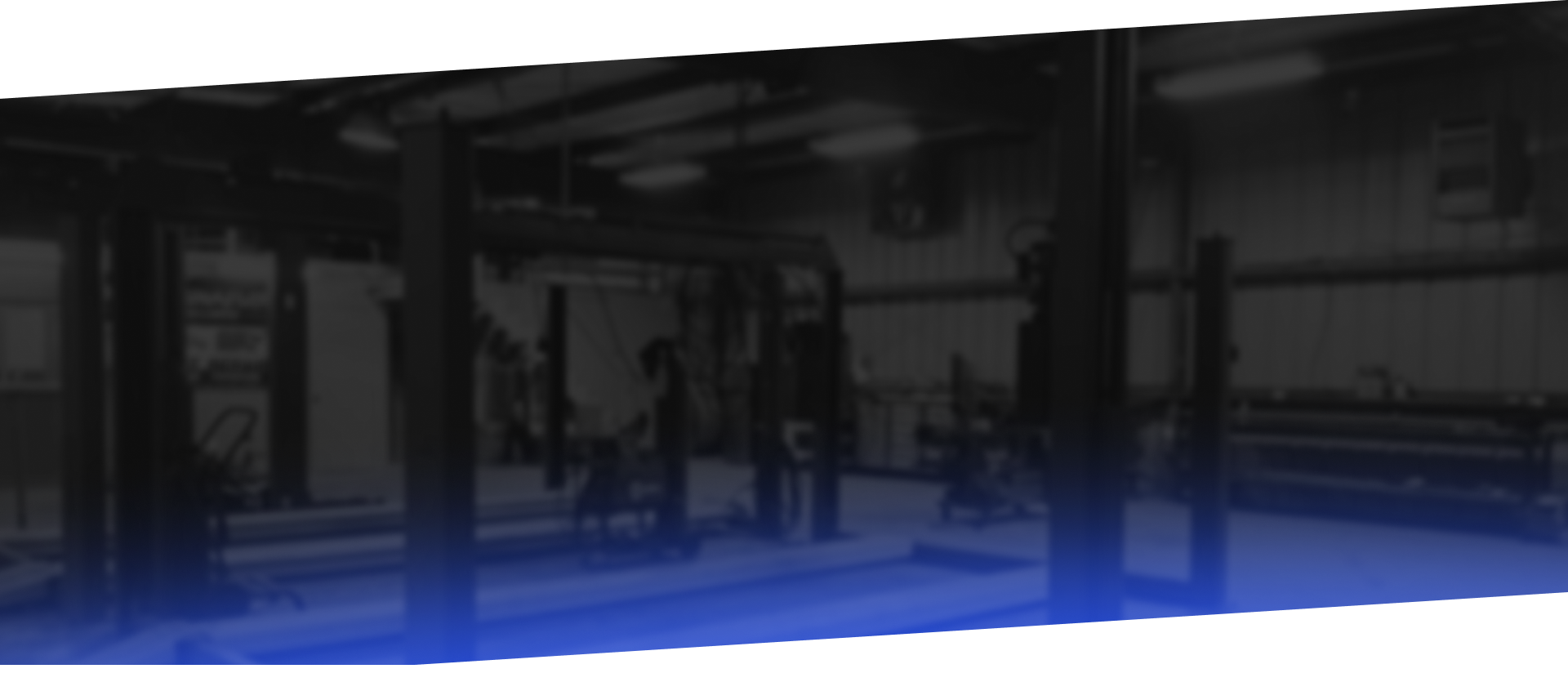 A dimly lit auto repair shop with vehicle lifts and work bays, a blue gradient at the bottom.