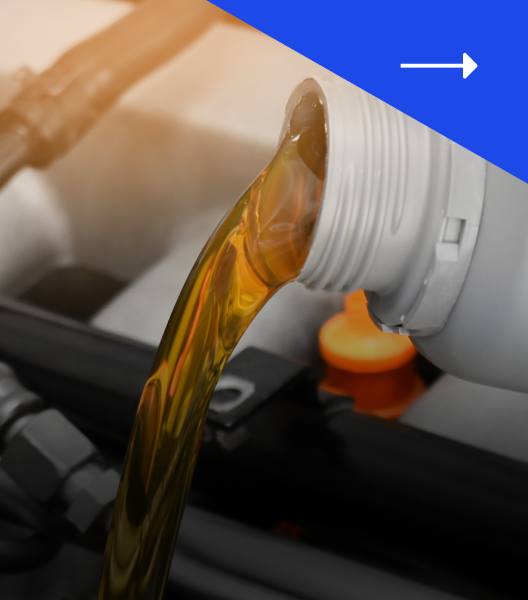 Oil being poured from a white container into a car engine.