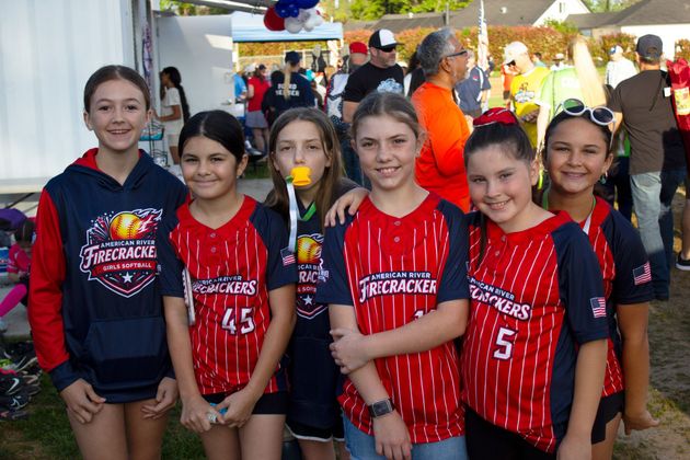 Youth softball players with red Firecrackers jerseys. 
