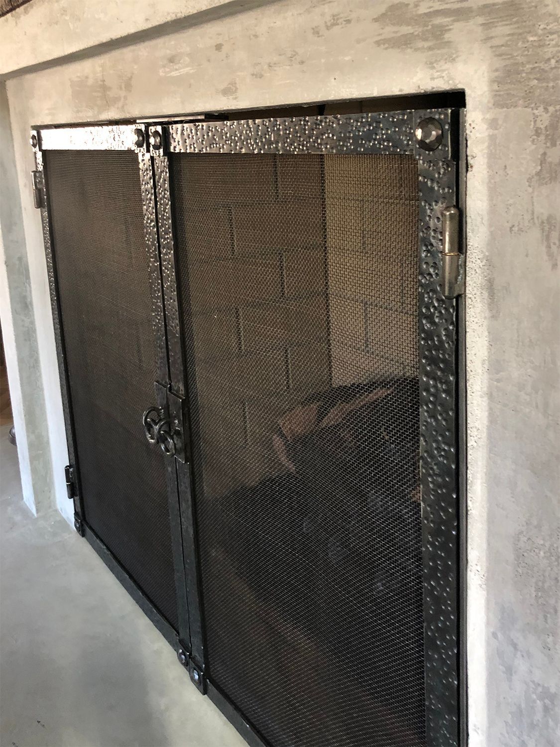 Black metal mesh fireplace doors.