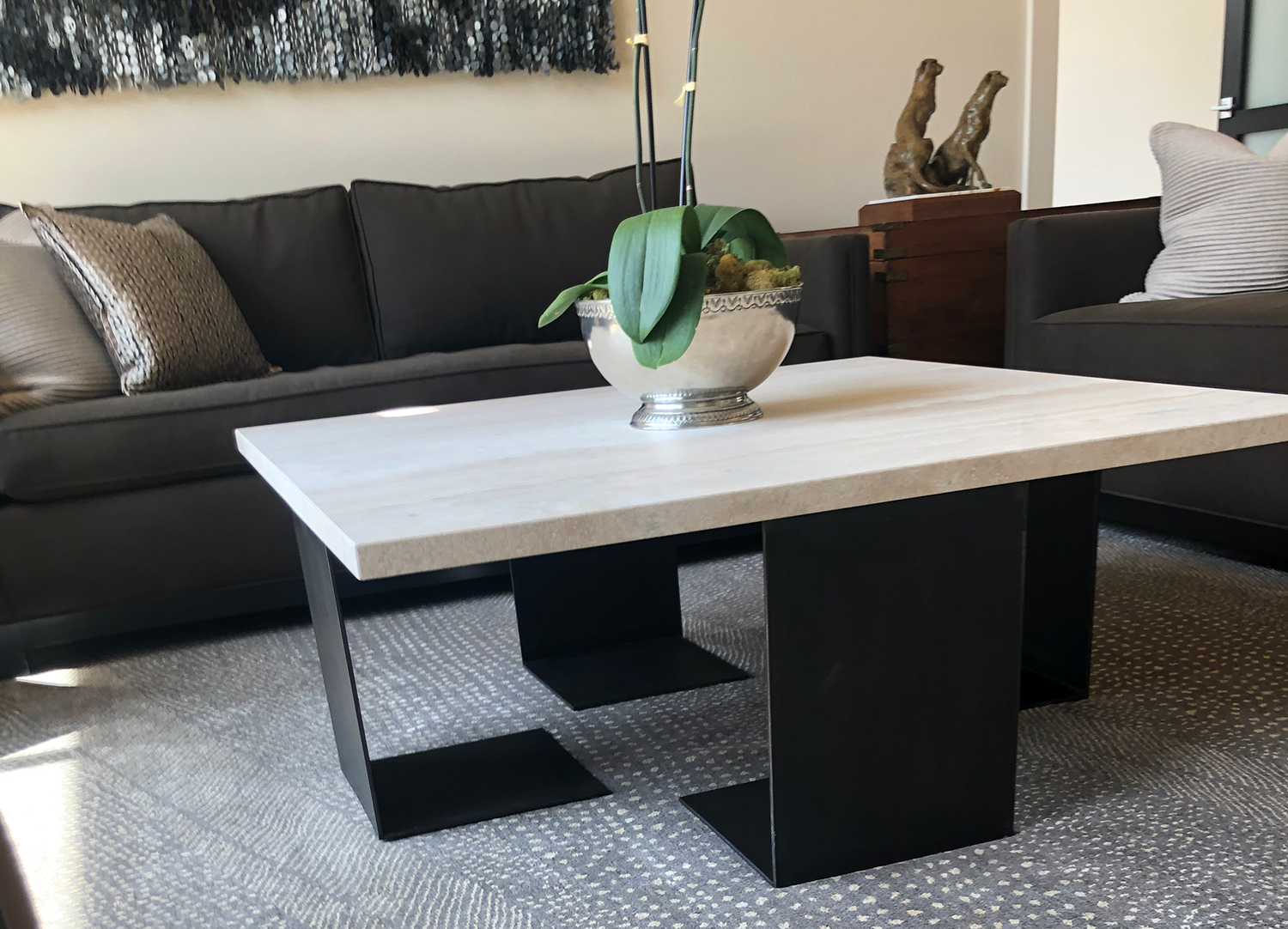 Modern living room with a gray sofa and a square coffee table with a white top and black legs.