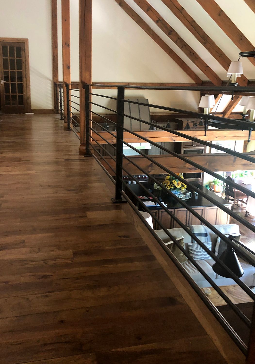 Interior view: Wooden floor with a railing and exposed beams overhead.