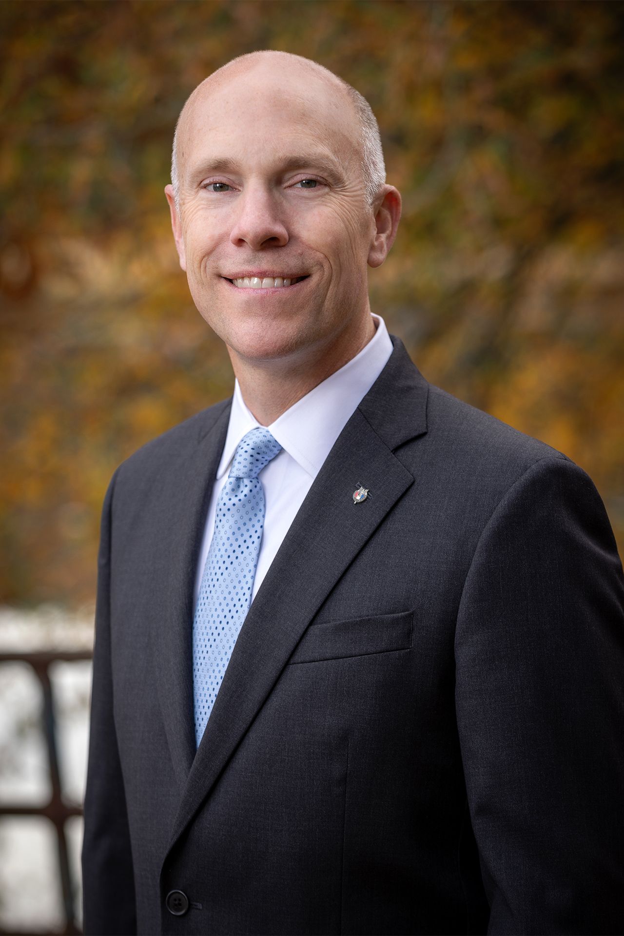 a man in a suit and tie is smiling for the camera .