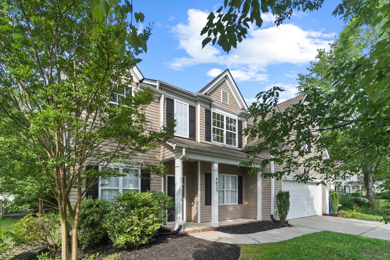 A large house with a porch and trees in front of it in Charlotte, NC shot by Hometrack team