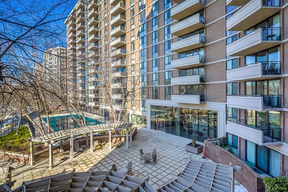 A large apartment building with a patio in front of in rush hour downtown Chevy Chase. Shoot by Hometrack Photographer Team